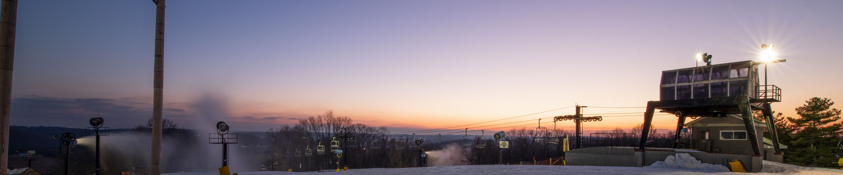 Sunset on the slopes with snow guns on at Paoli Peaks
