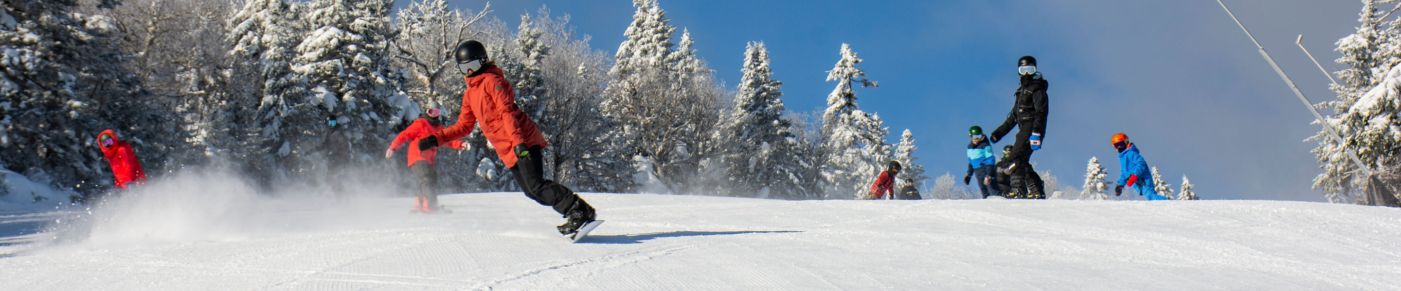 Guests snowboard while at Okemo