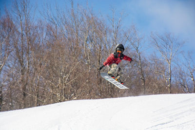 A snowboarder jumps at Okemo