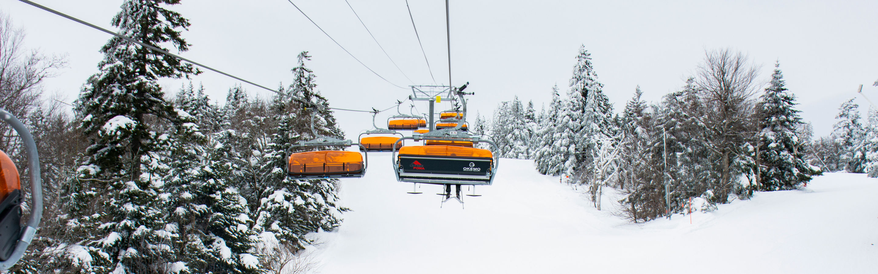 Snowboarding underneath the chairlift at Okemo