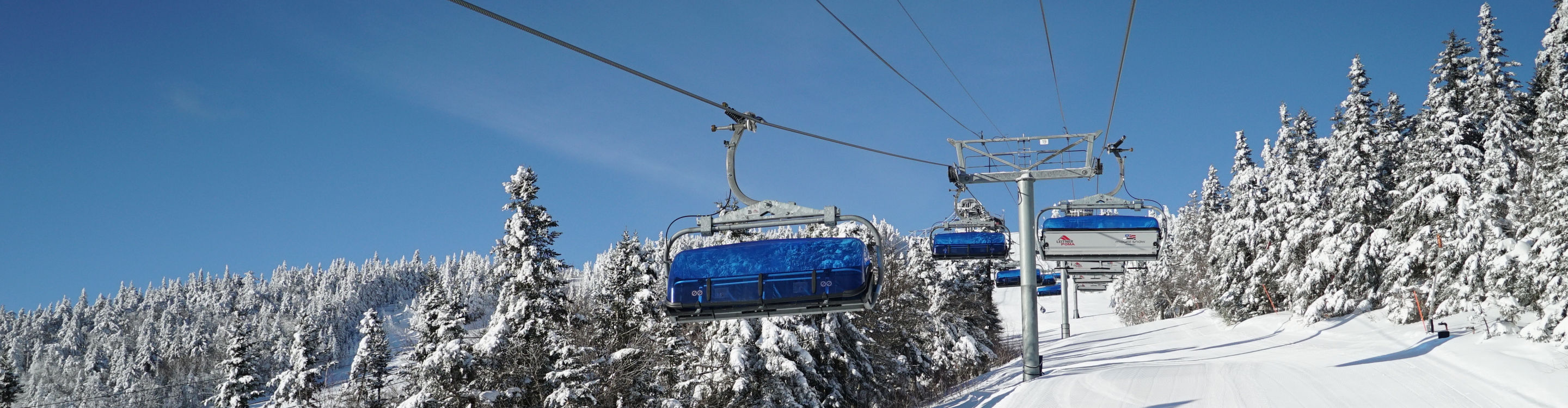 Bluebird Express over Lodge with Blue Skies and Snowy Trees at Mount Snow