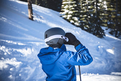Woman Adjusts Oakley Goggles while wearing Helly Hansen at Northstar