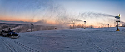 Sunset panoramic on the slopes with snow guns on at Paoli Peaks