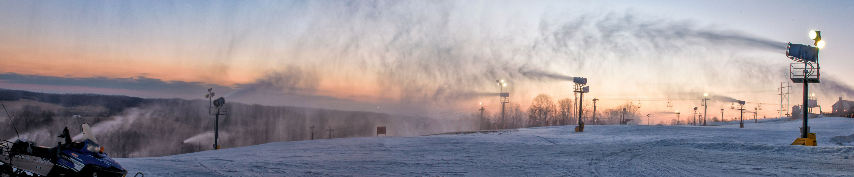 Sunset panoramic on the slopes with snow guns on at Paoli Peaks