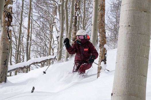 Skier in knee-high powder amidst the aspen trees at Vail