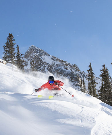 Skier making turn in fresh snow with Mount Crested Butte in the background