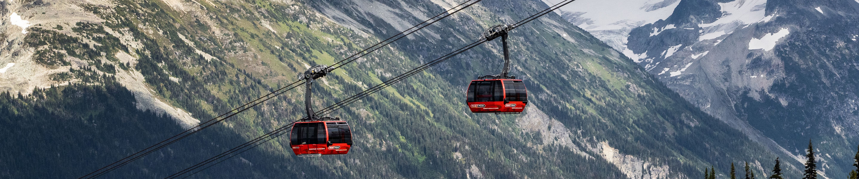 Scenic Shot of Gondolas at Whistler Blackcomb During Summer with Some Remaining Snow on the Mountaintops