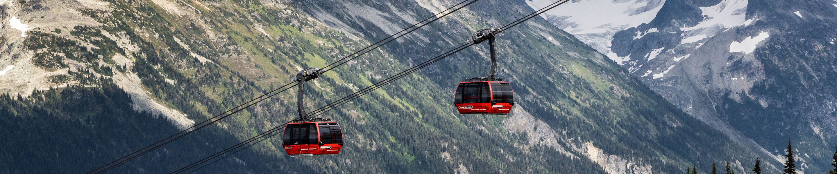 Scenic Shot of Gondolas at Whistler Blackcomb During Summer with Some Remaining Snow on the Mountaintops