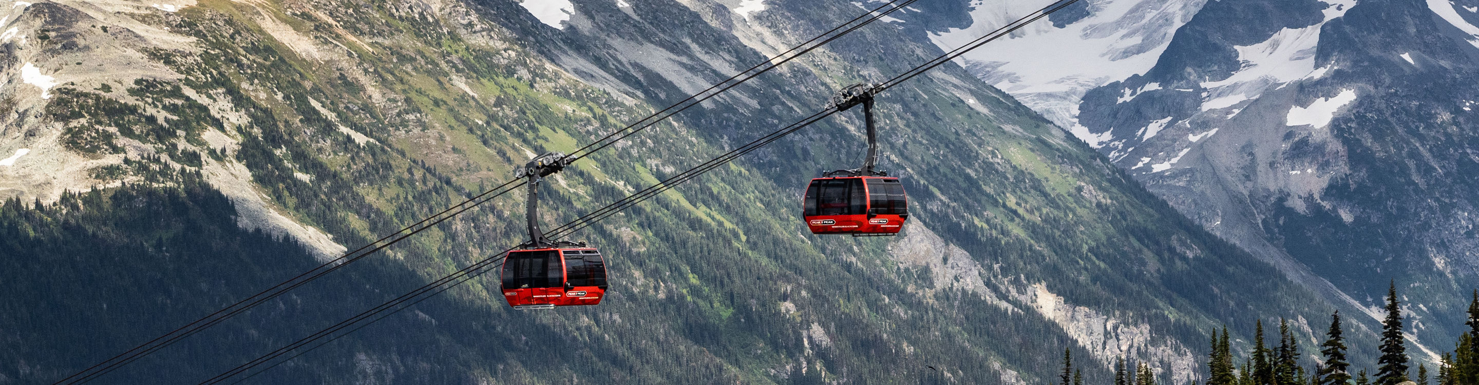 Scenic Shot of Gondolas at Whistler Blackcomb During Summer with Some Remaining Snow on the Mountaintops
