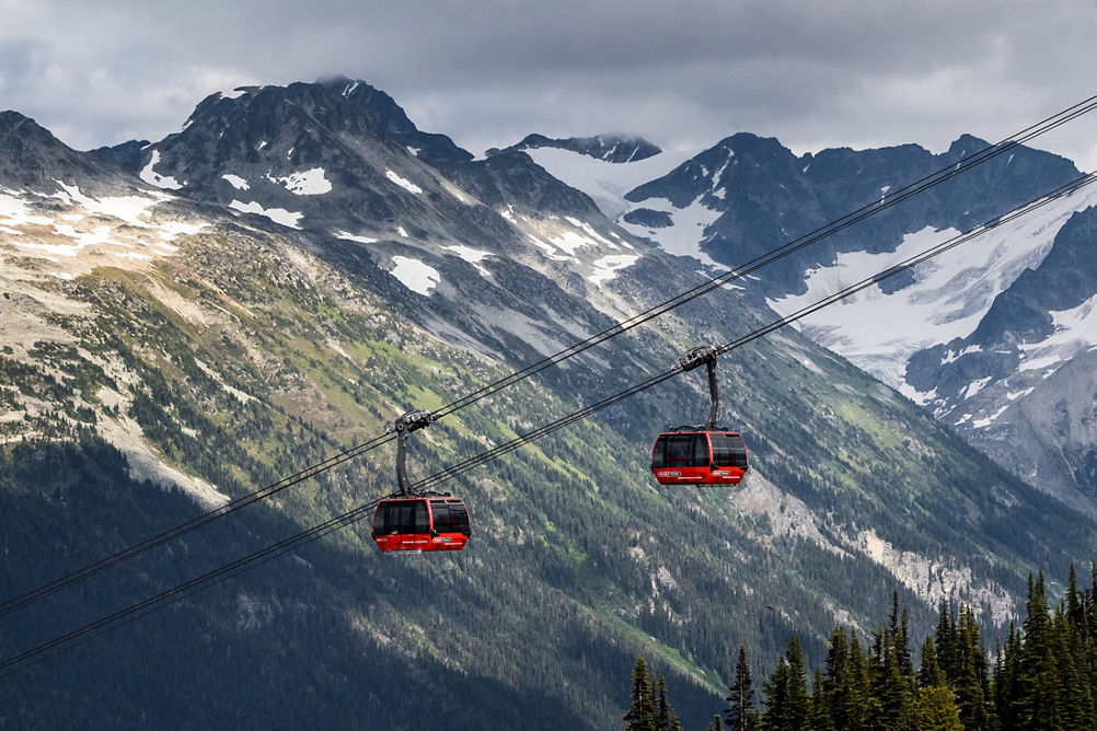 Scenic Shot of Gondolas at Whistler Blackcomb During Summer with Some Remaining Snow on the Mountaintops