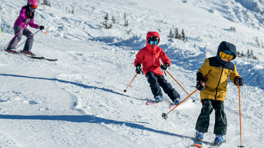 Older children skiing with instructor