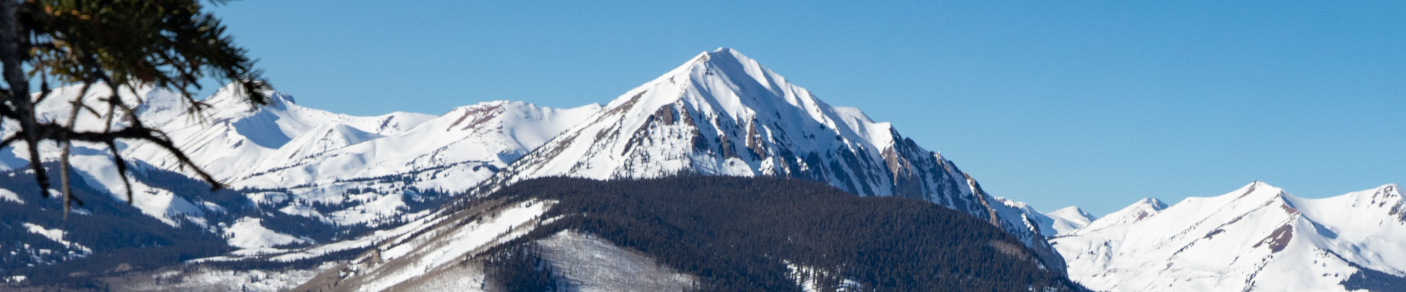 Skier making turn down Funnel with Gothic Mountain in the background