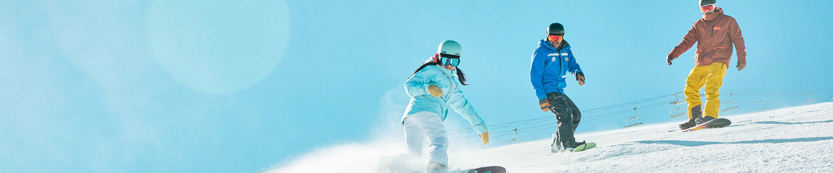 Adults snowboarding with an instructor