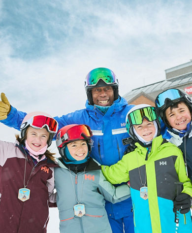 Older children skiing with an instructor (ATP)