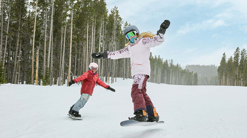 Older children snowboarding with an instructor (ATP)