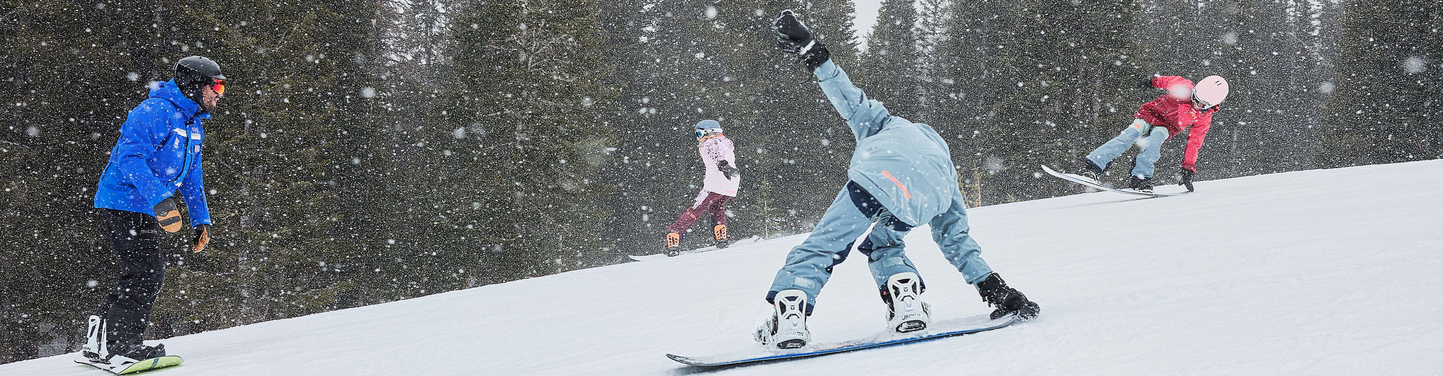 Older children snowboarding with an instructor (ATP)