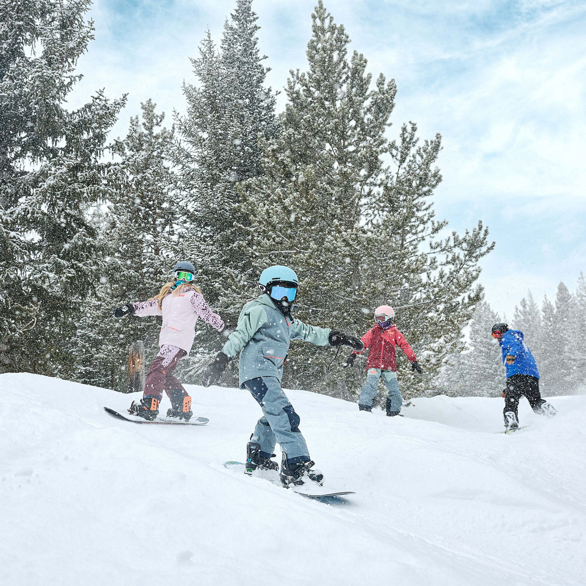 Older children snowboarding with an instructor (ATP)