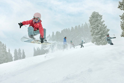 Older children snowboarding with an instructor (ATP)