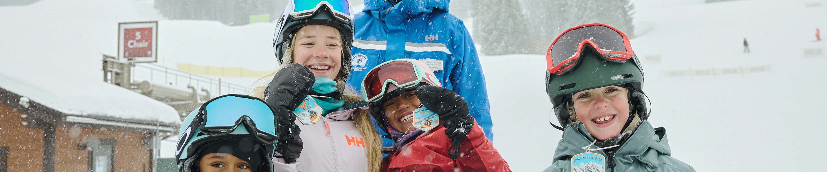 Older children snowboarding with an instructor (ATP)