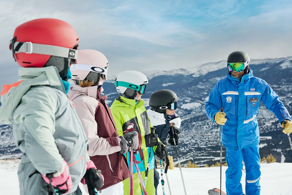Older children skiing with an instructor (ATP)