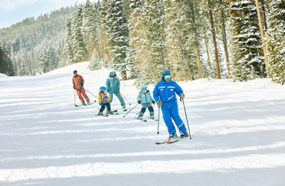 Family skiing with an instructor in a private lesson