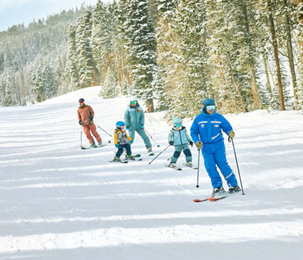 Family skiing with an instructor in a private lesson