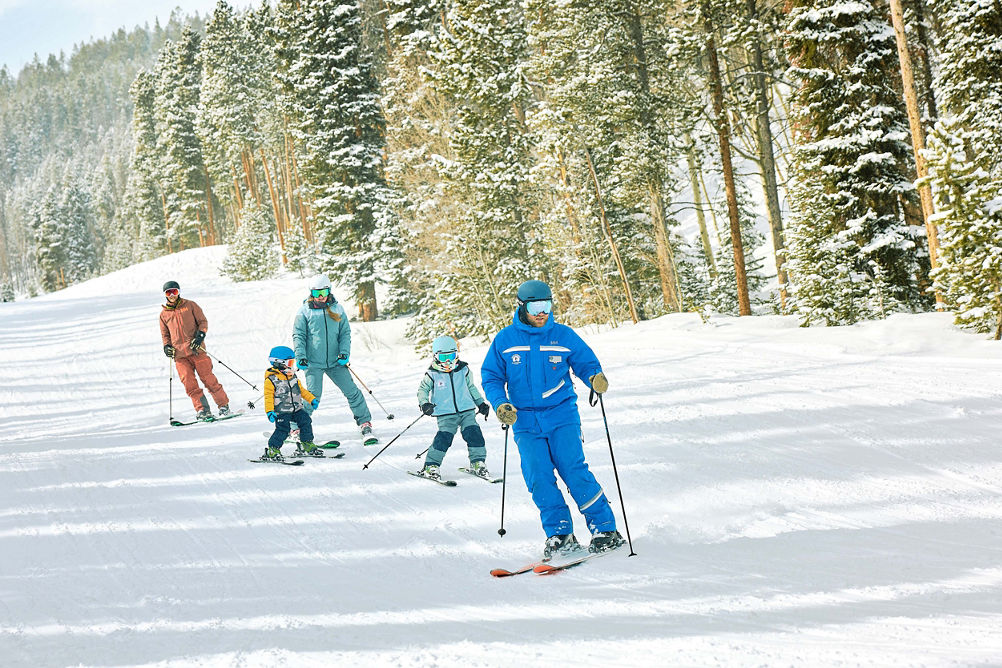 Family skiing with an instructor in a private lesson