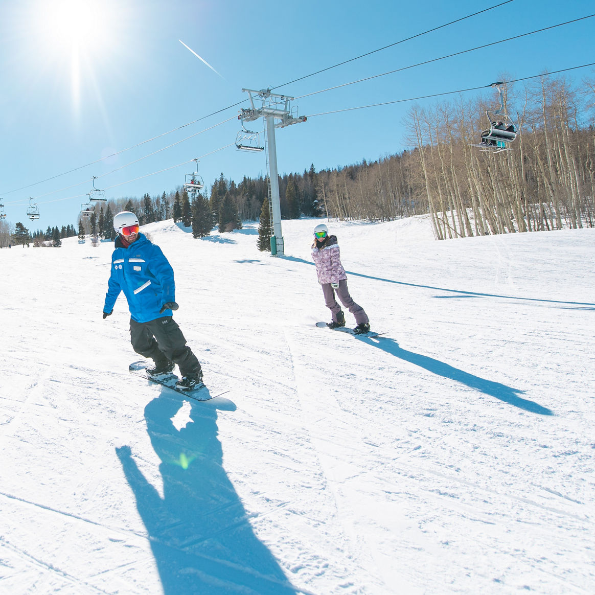 Adults snowboarding with an instructor