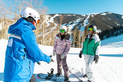 Adults snowboarding with an instructor