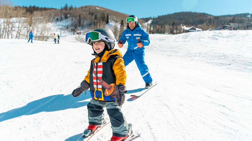Young children skiing with an instructor
