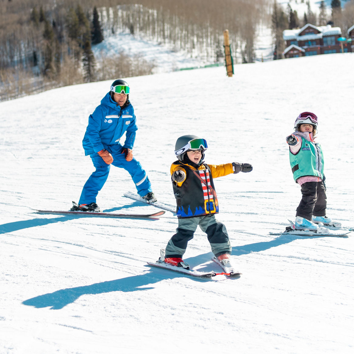 Young children skiing with an instructor