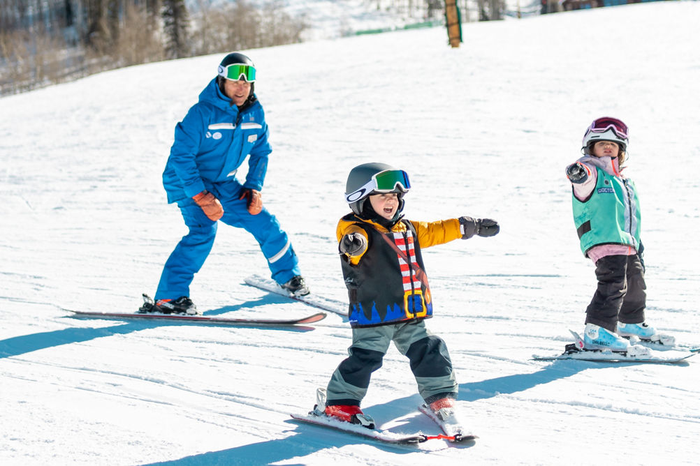 Young children skiing with an instructor