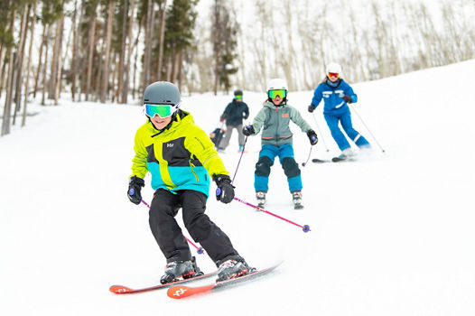 Older children skiing with an instructor