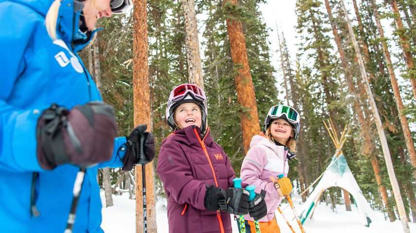 Young children skiing with an instructor