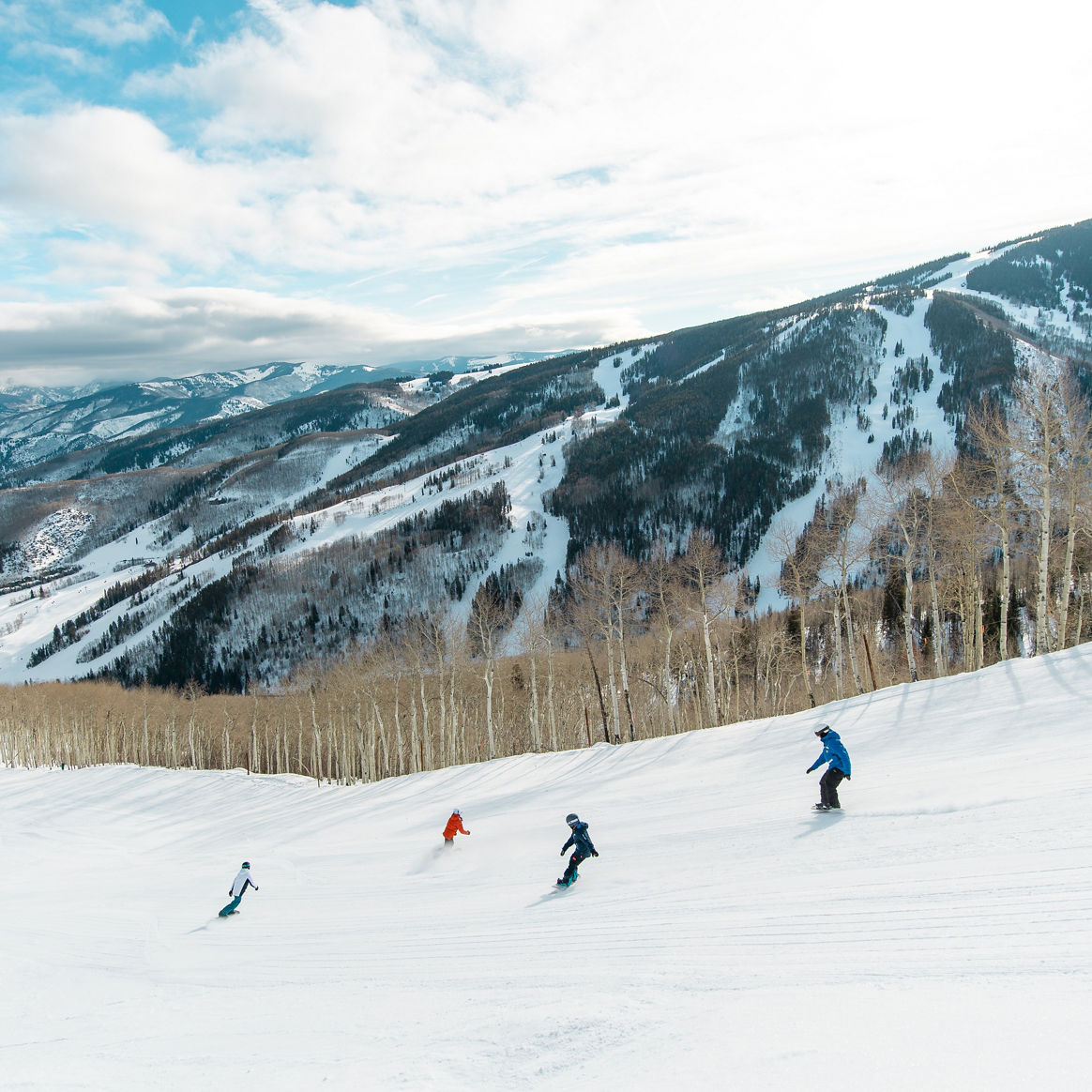 Older children snowboarding with an instructor