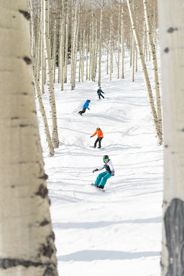 Older children snowboarding with an instructor