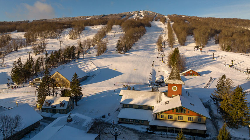 Mount Snow Main Base Area with Clocktower and Bluebird Barn at Sunrise with Mountain in Background