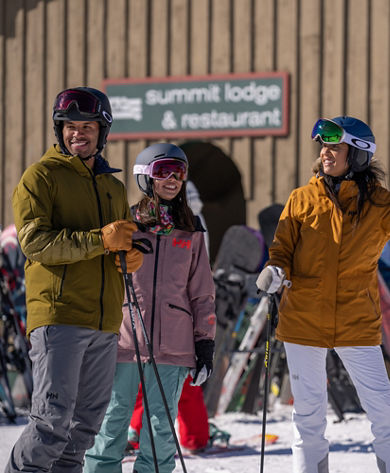 Friends Plan Trail in front of Summit Lodge and Bullwheel Sign at Mount Snow Summit