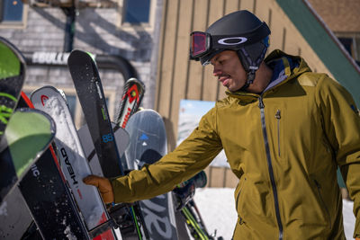 Man Grabs Skis from Rack at Summit of Mount Snow