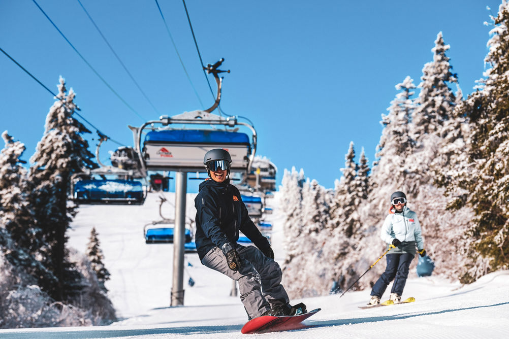 Couple on Snowboard and Skis Smile under Bluebird Express at Mount Snow