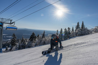 Snowboarder Carves Corduroy Under Bluebird Express at Mount Snow