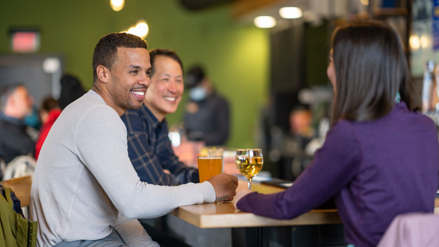 Friends Smile Over Drinks at High Timber Lounge in Carinthia Base Lodge at Mount Snow