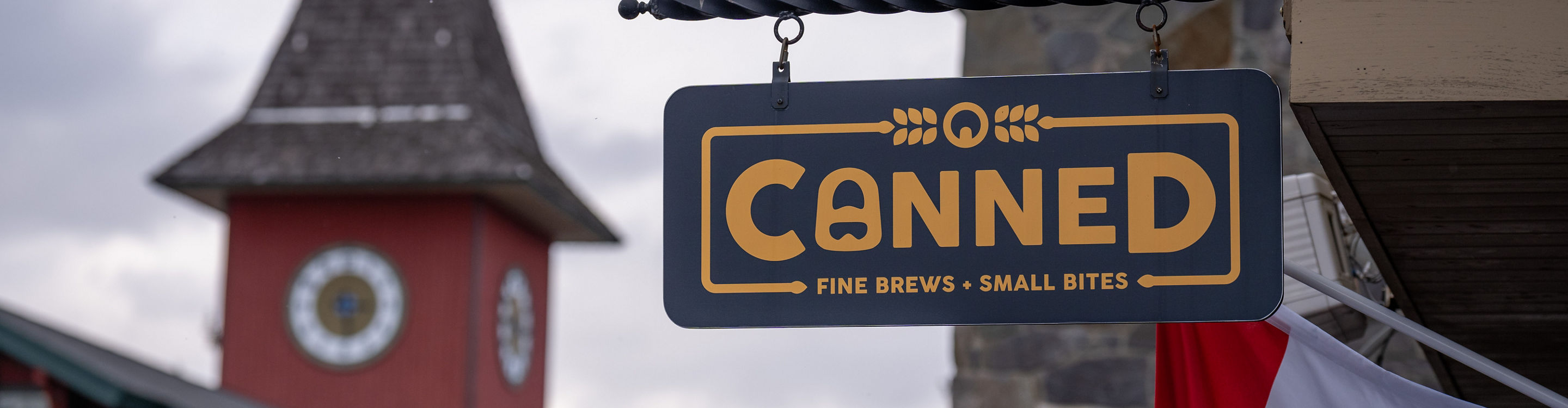 Canned Sign with part of Open Flag and Clocktower in Background at Mount Snow