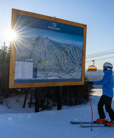 Ski Instructor Inspects Trail Map Sign at Okemo