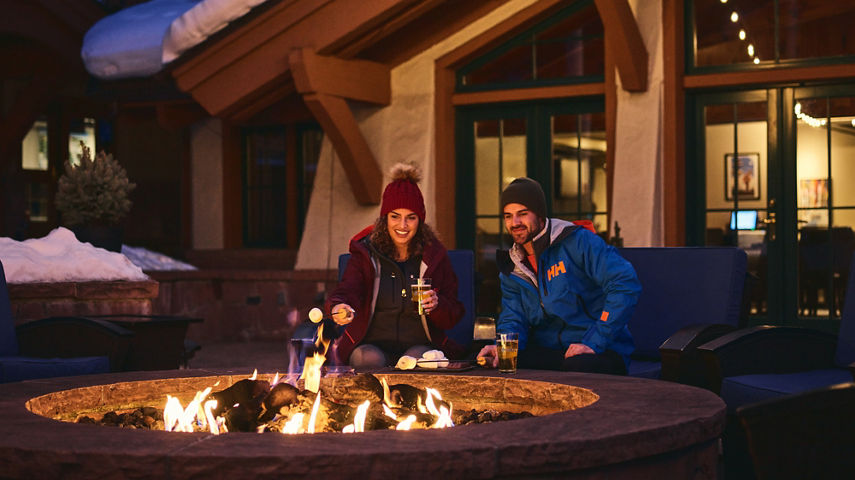 Couple sits by fireplace at The Lodge at Vail
