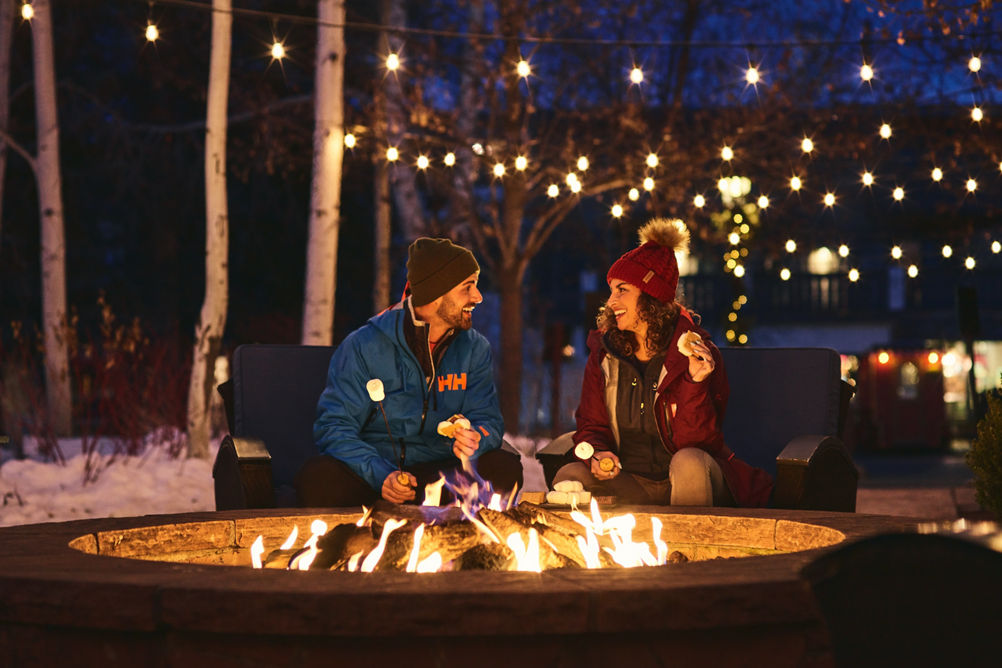 Couple sits by fireplace at The Lodge at Vail
