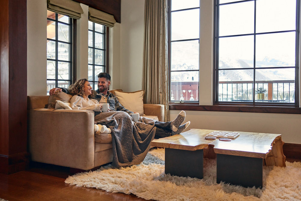 Couple sits on couch in living room at The Lodge at Vail
