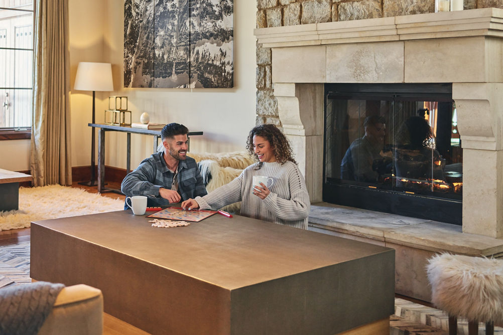Couple plays board game in living room at The Lodge at Vail