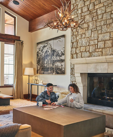 Couple plays board game in living room at The Lodge at Vail