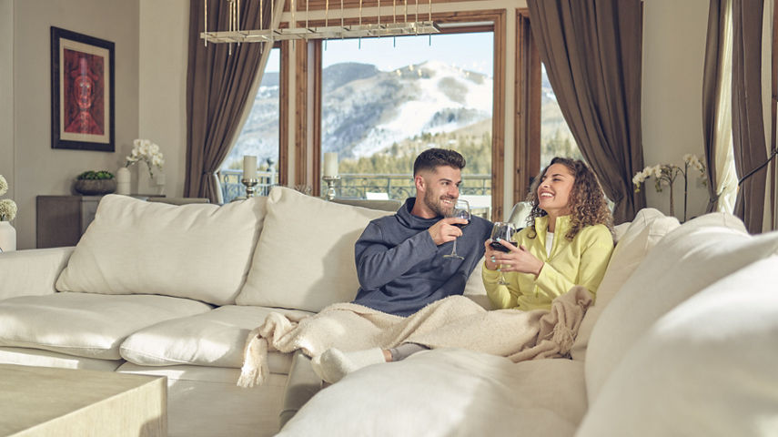 Couple drinking wine on the couch at The Arrabelle